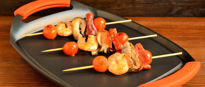 Brochetas de pescado, marisco y jamón